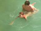 Slim nudists have explicit fun in the warm water