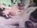 A girl is half laying, half sitting on a couch surrounded by three men. She is sucking the dick of one of them while the second guy licks her pussy and the third one is playing with her tits. Then she gets fucked by all three of them in turn.