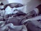 A half naked guy with his head in bandages is laying on a bed. On either side of him are two nurses who wash his dick. A little later one of the nurses is on top of the guy, fucking him until he comes on her hairy pussy.