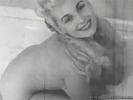 A blonde girl is in the bathroom. She is completely naked and fills up the bath while she is swaying her body, showing her firm tits. When the bath is full she steps into the water and plays with the suds.