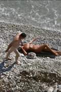 Three sexy ladies sunbathe nude right near the sea