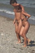 A couple of sexy tanned nudists enjoy sun and sea