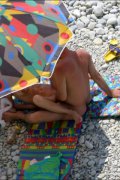 Two nudists change sex positions near the waves